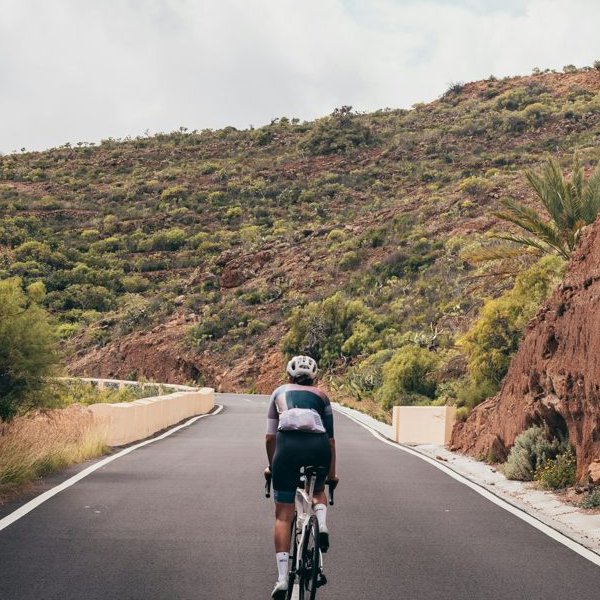 A cyclist riding up a canyon road